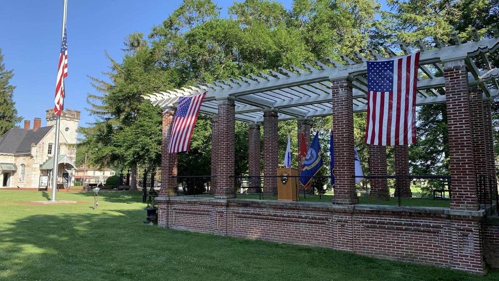 red brick platform with painted white shade roof draped with red, white, and blue bunting