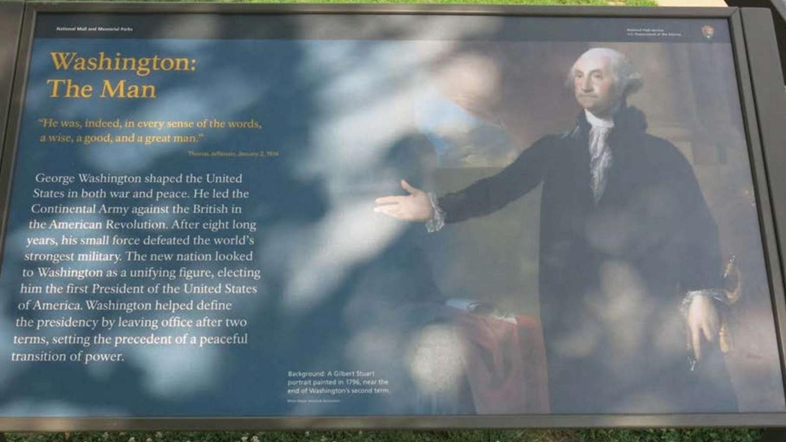 Wayside with painting of a man extending left hand towards text while holding sword in other hand.