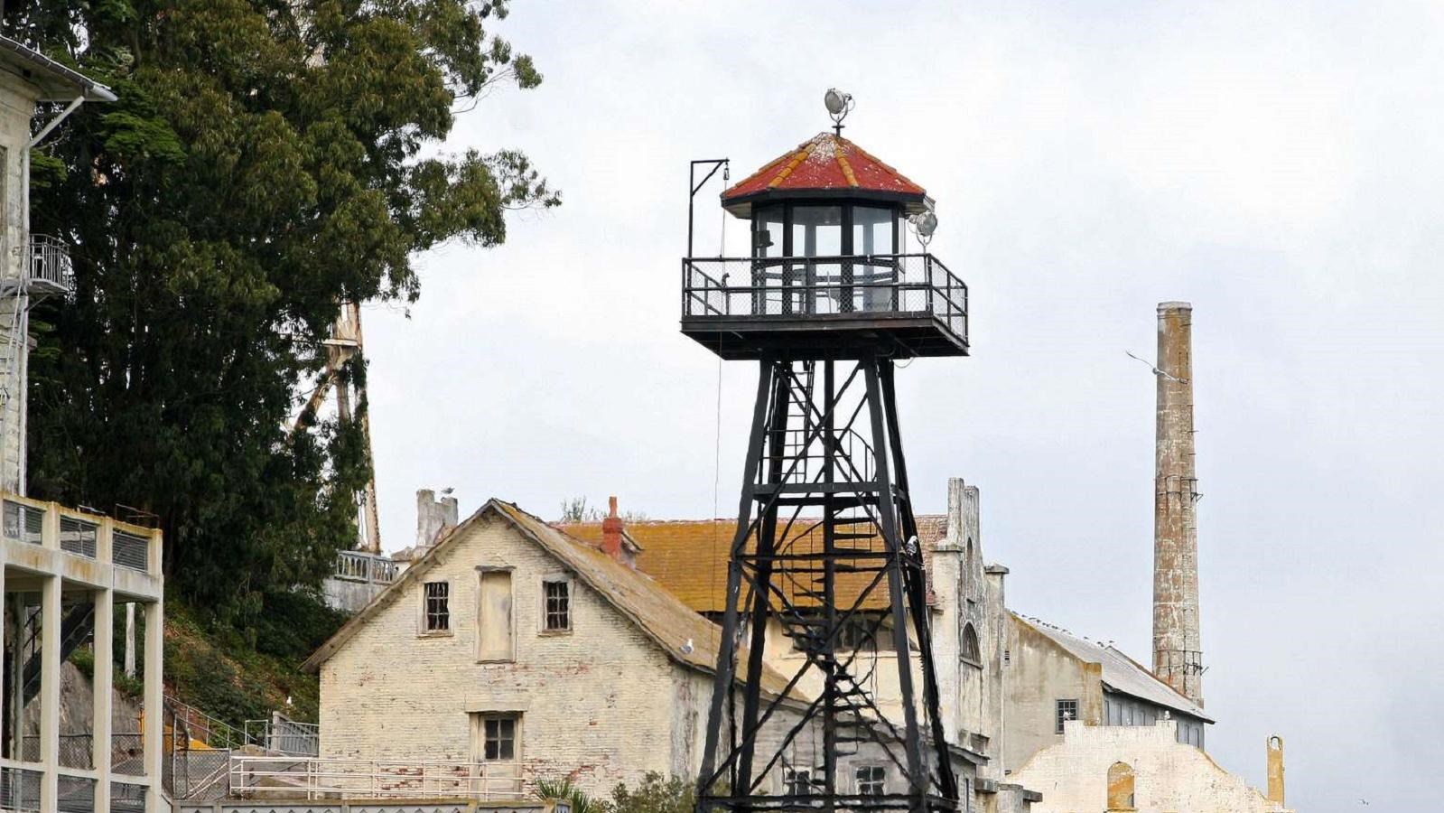 The Alcatraz guard tower with black metal struts and a red roof.