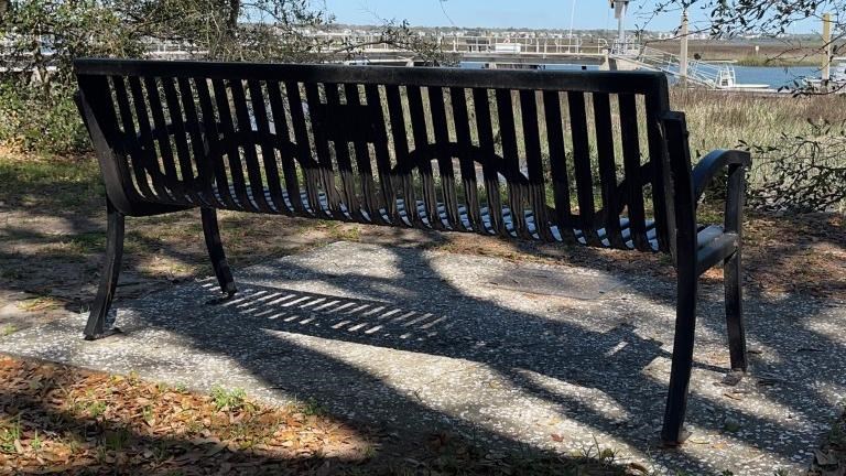 A black metal bench faces the intercoastal waterway