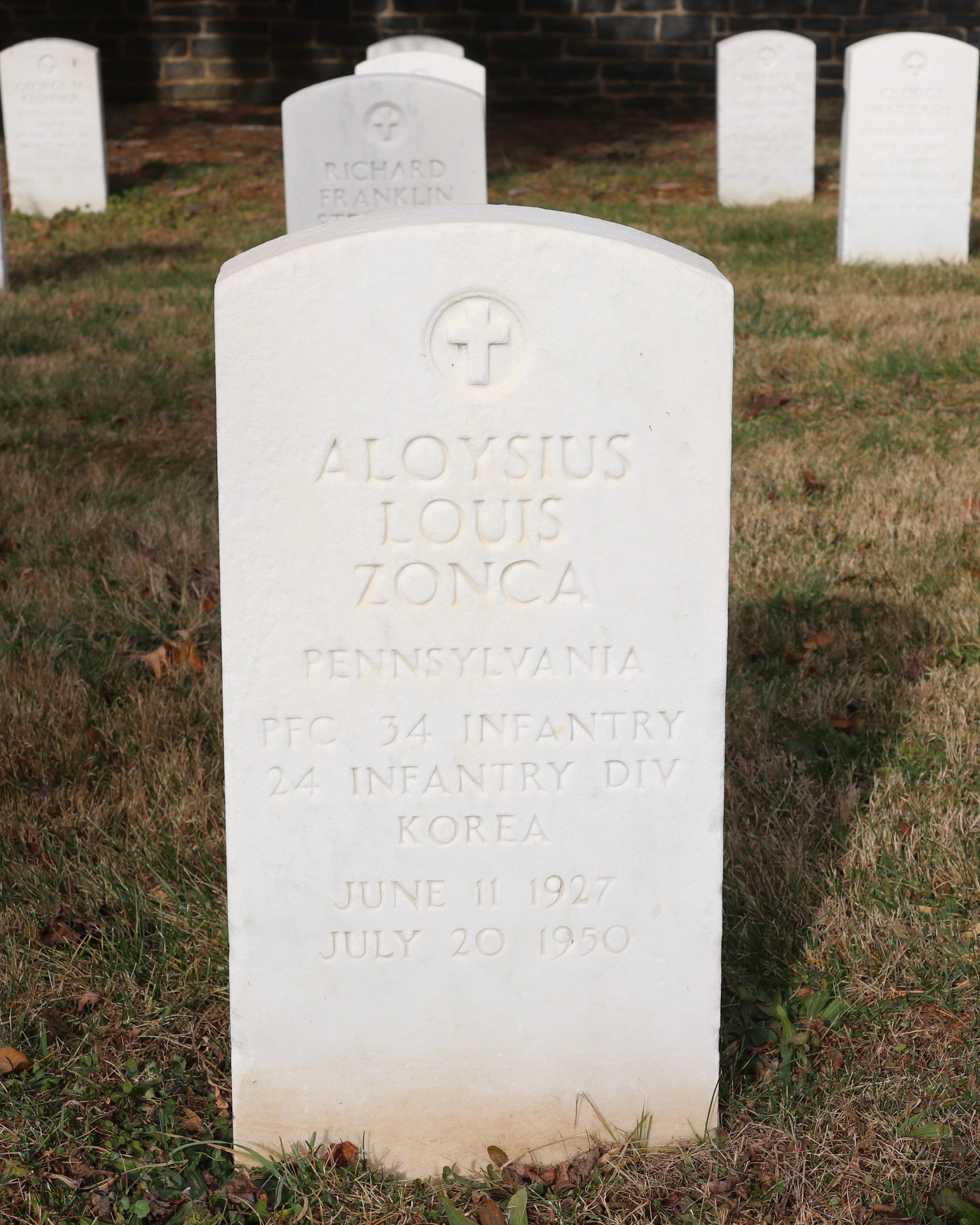 A white marble headstone with other headstones to the sides and rear of it