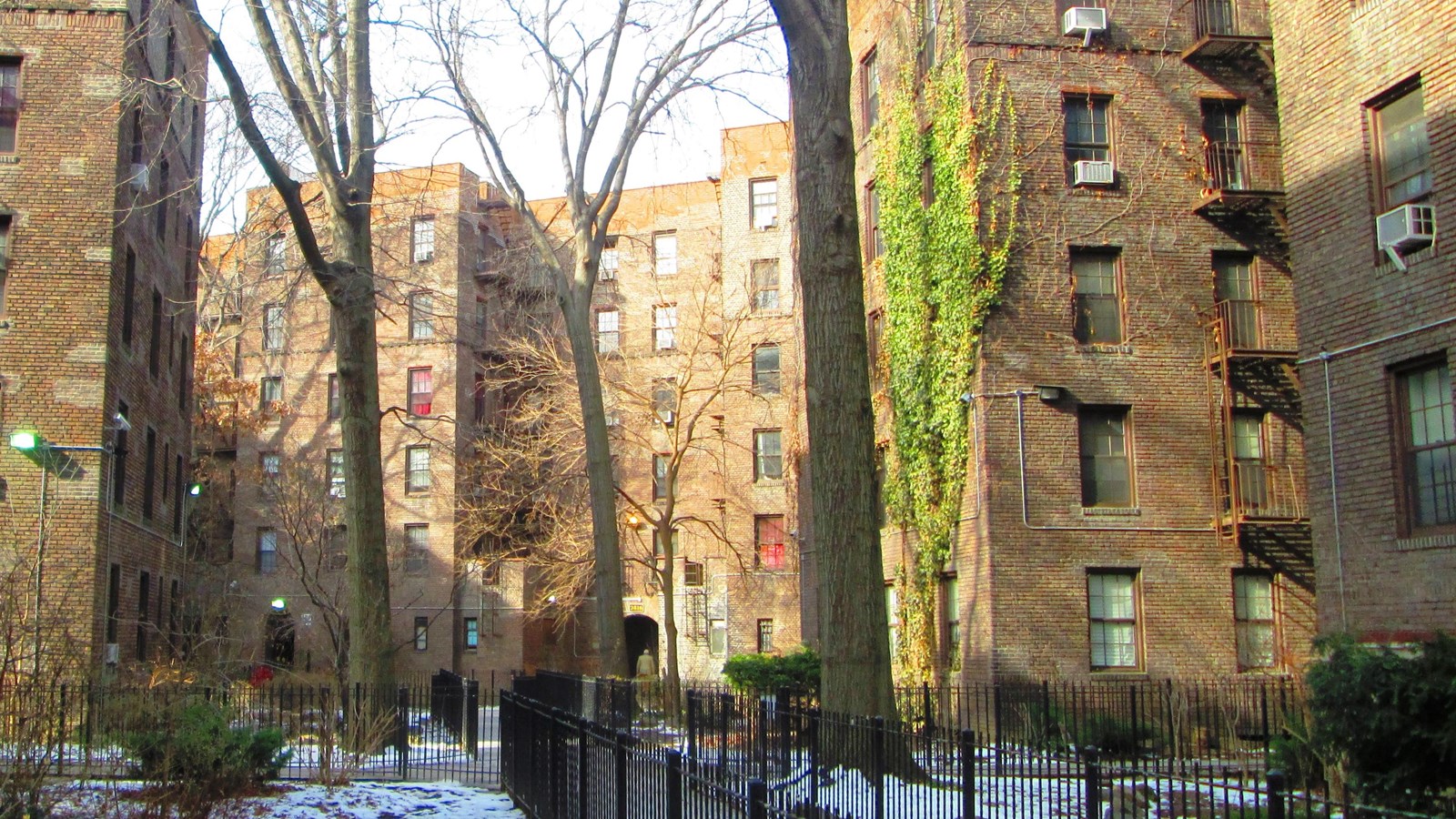 Photo of an apartment complex, several stories made of brick. 