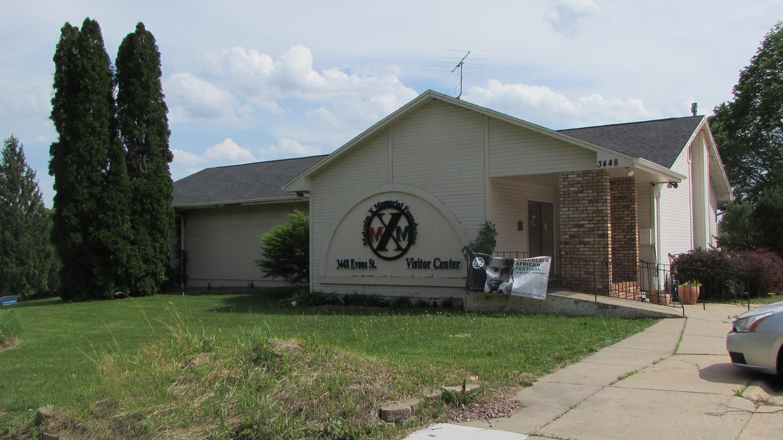 Frame building that serves as Malcolm X Museum. One-story, cross-gabled, parking lot and landscaping