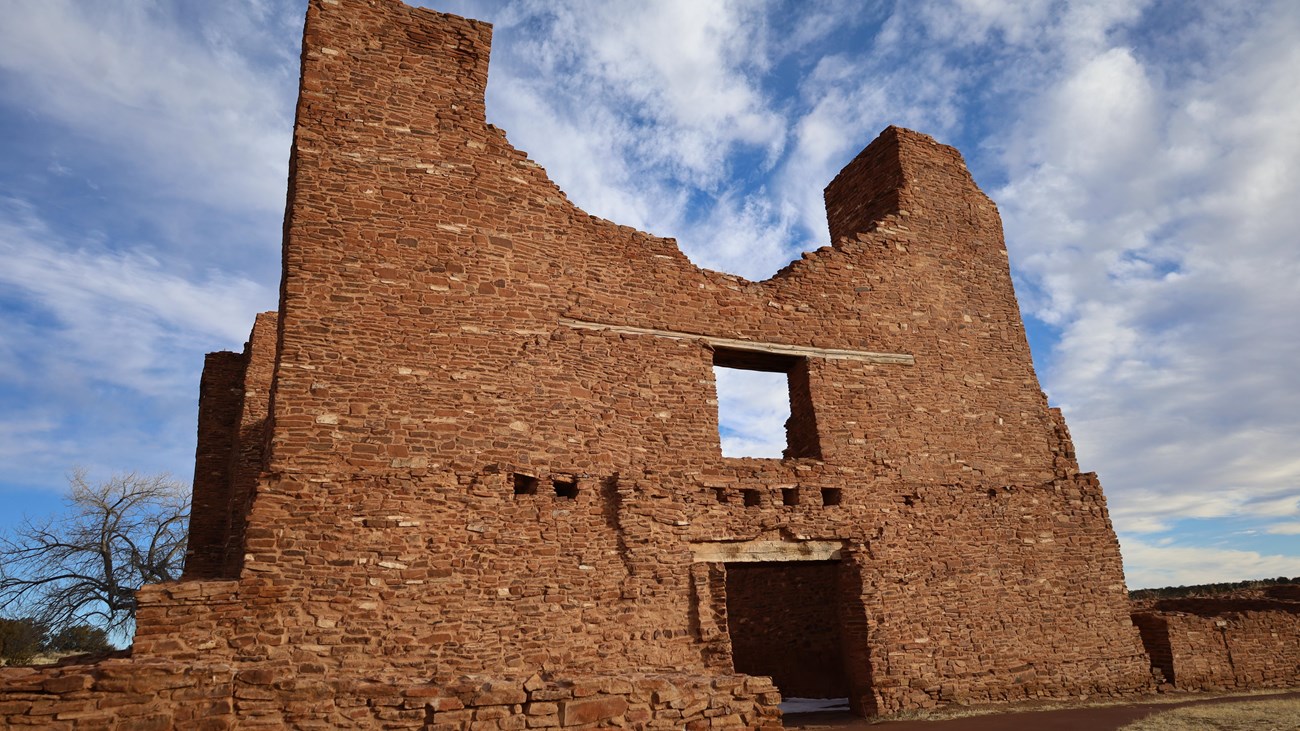 Red sandstone church ruins agains a cloud dotted sky