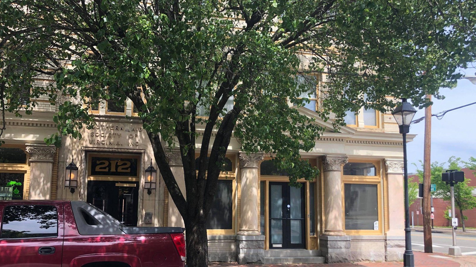 A yellow brick building with 212 above the doorway and Southern Aid Society of Virginia etched above