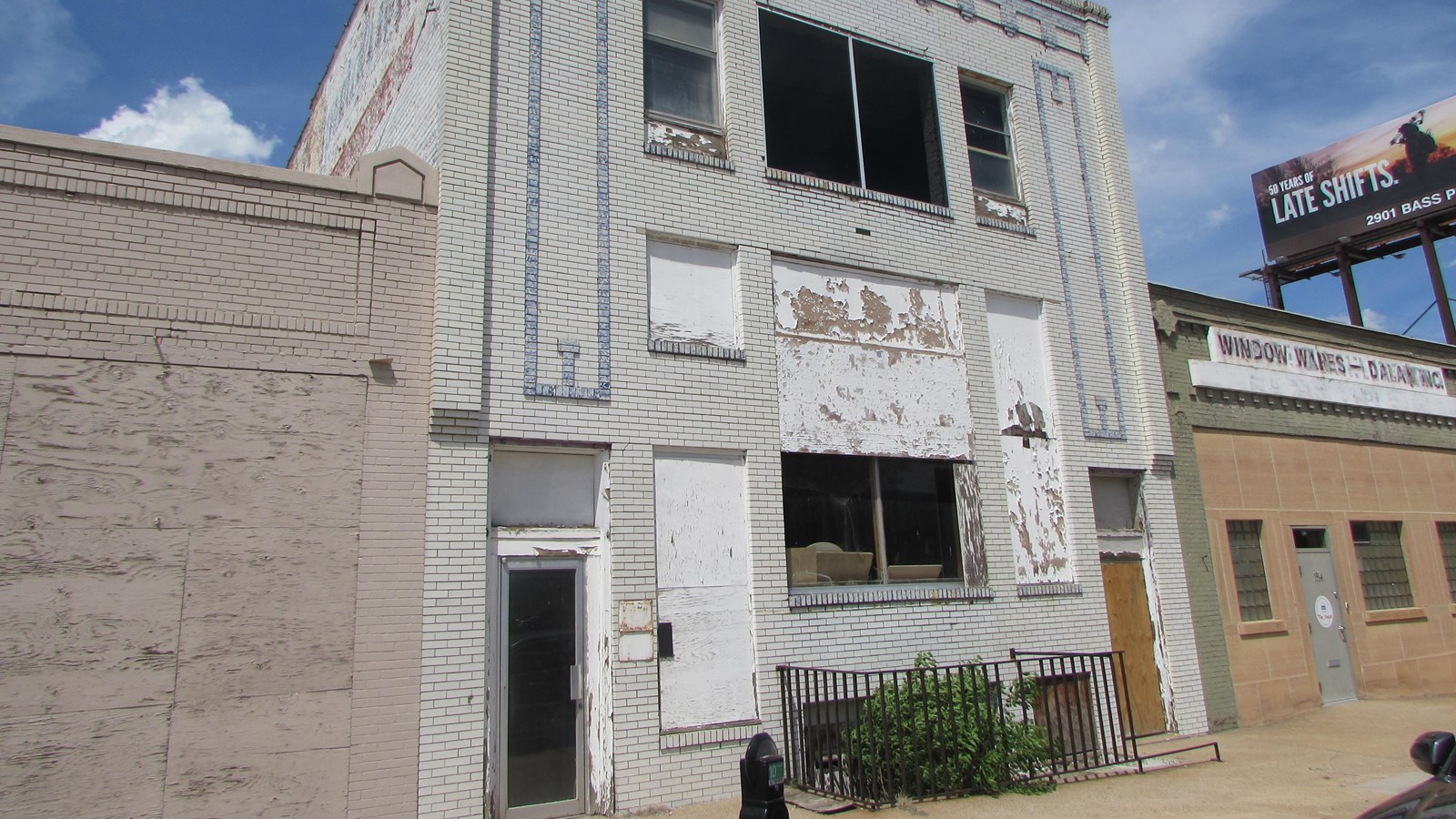 Two-story commercial building. Single windows flanking paired windows at first and second floors. 
