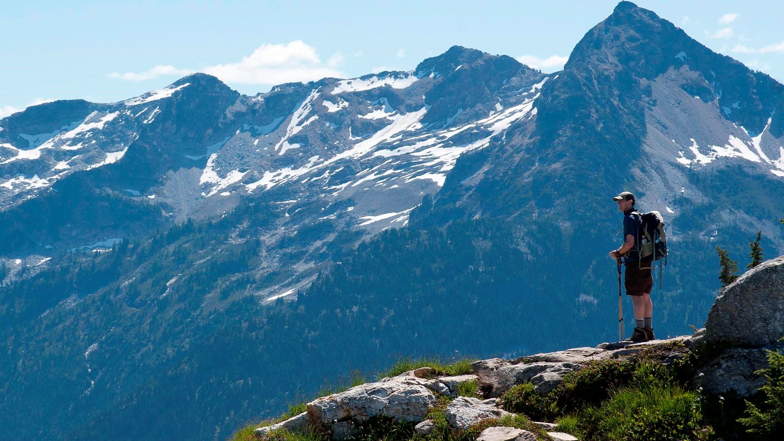 A hiker stands looking at a scenic mountain view.