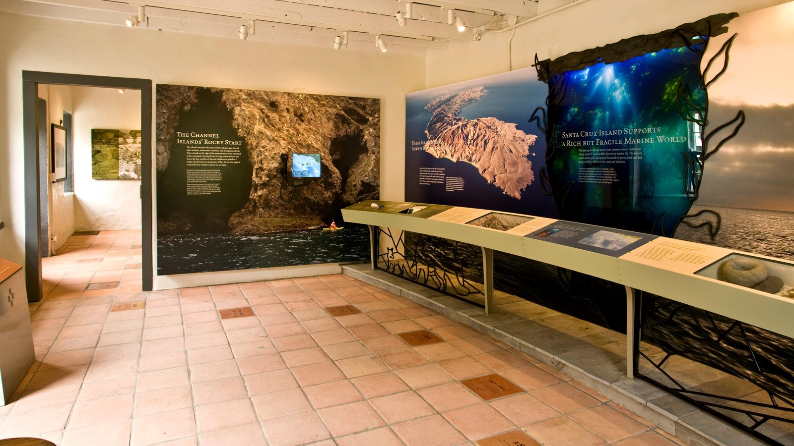 room interior with exhibits, tile floor, and video screen.