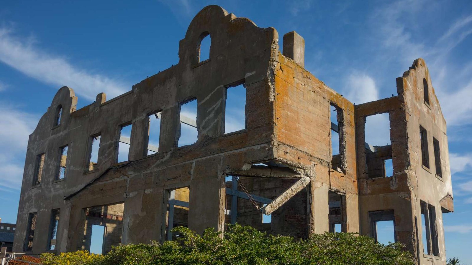 The outer concrete shell of the original three story structure with many windows.