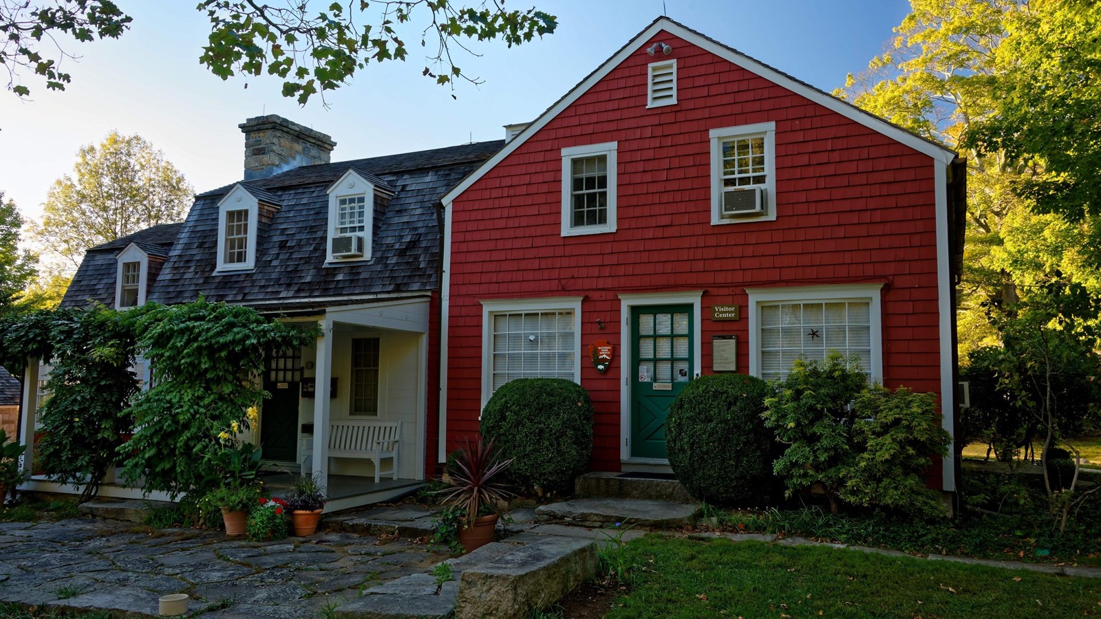 A red house with white trim and a green door.