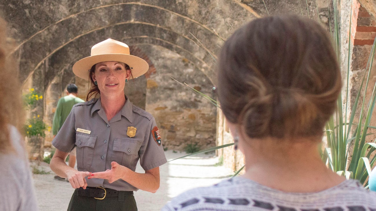 Park Ranger leads a family through the convento at Mission San Jose