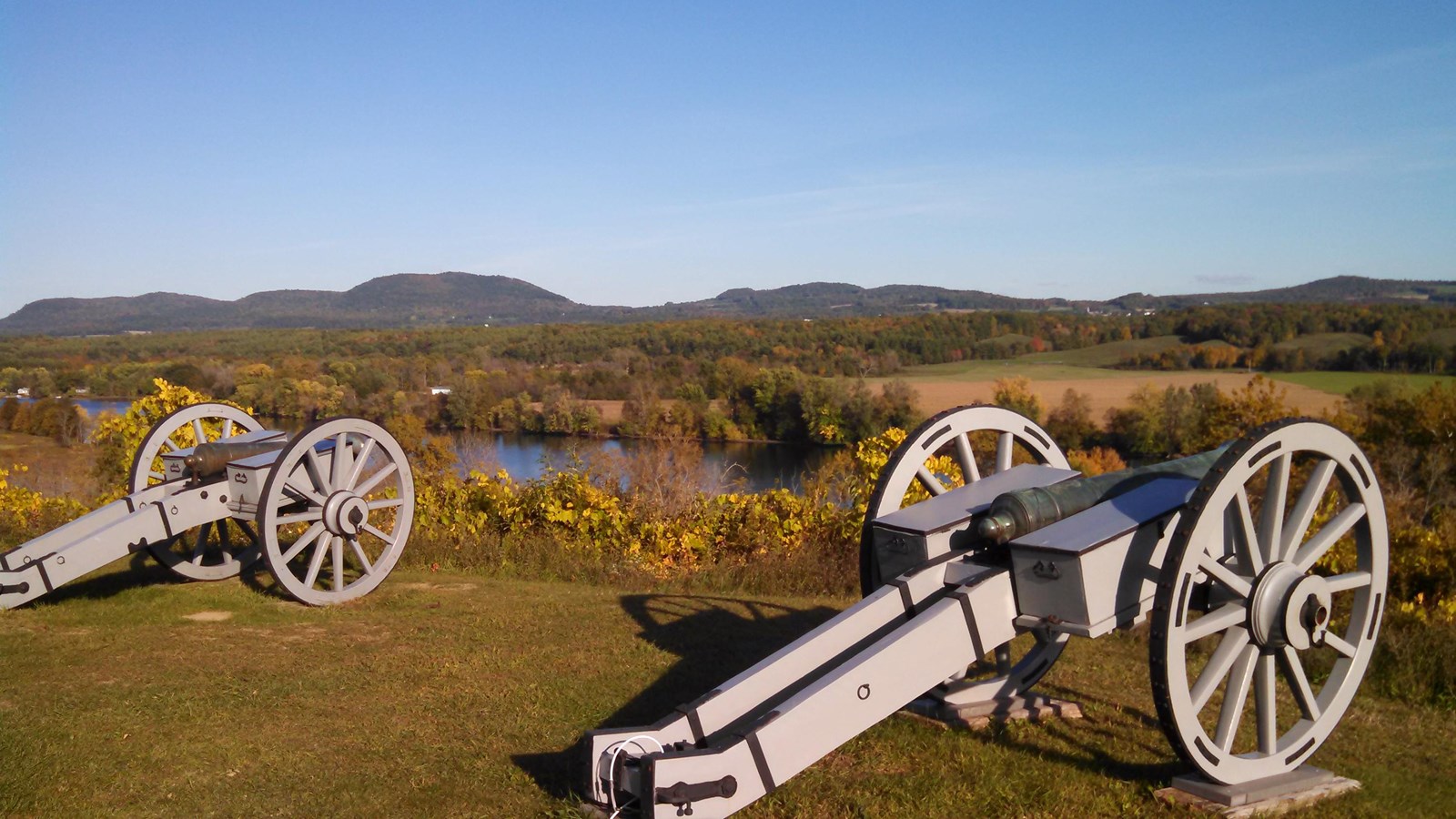 Two gray cannons overlooking the river