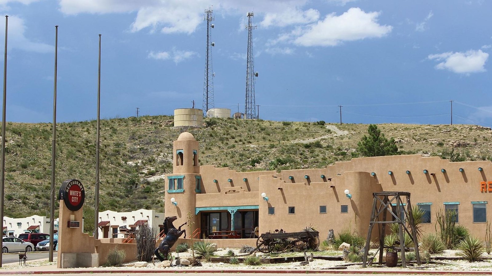 An adobe style commercial building with a desert hill behind it. 