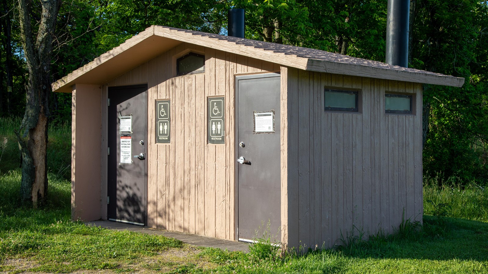 A rectangular building with two doors into restrooms.