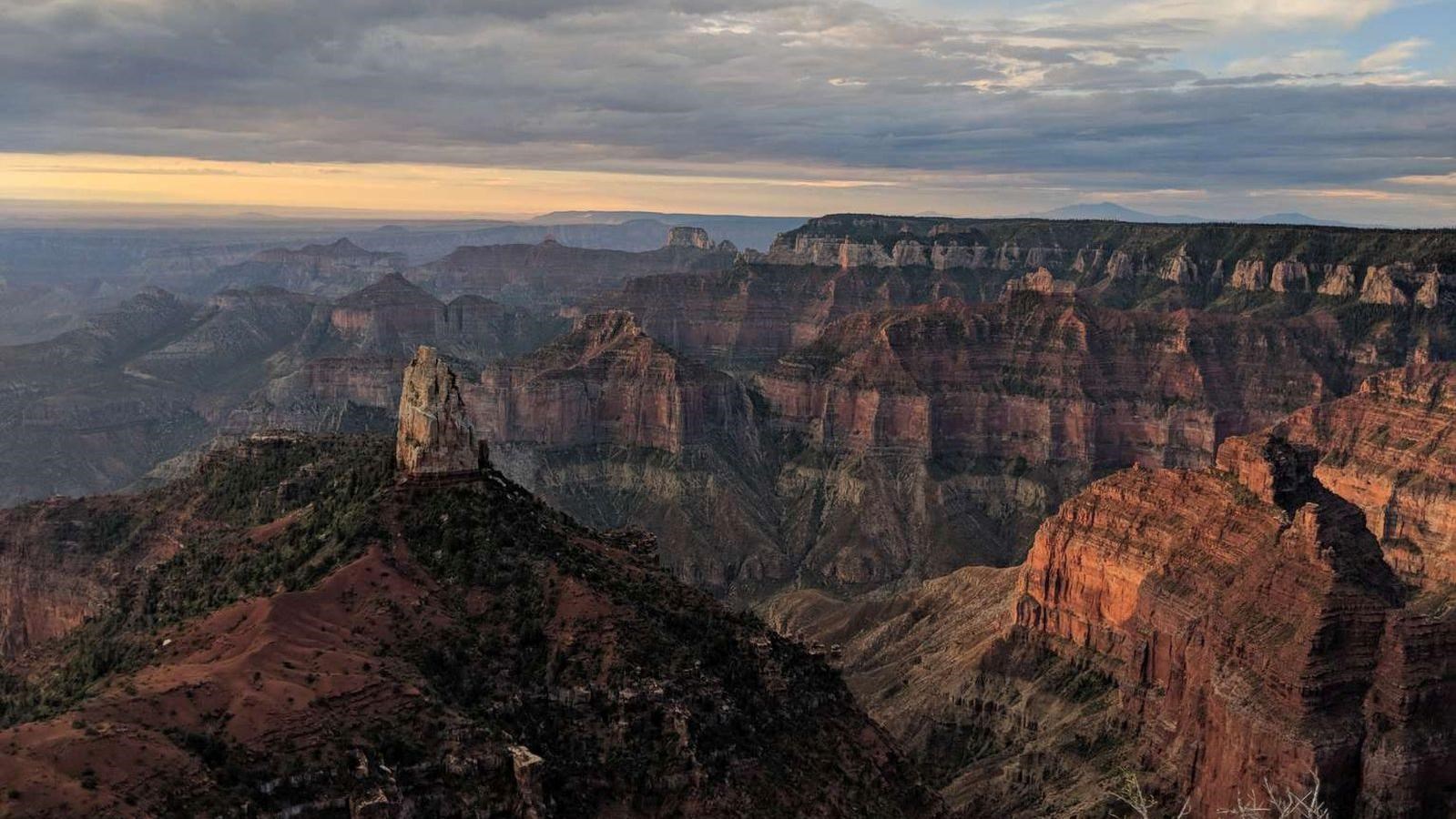 A prominent formation with a white rock spire against the backdrop of the red cliffs of Grand Canyon