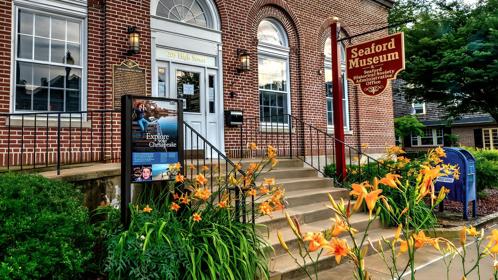 A brick building with a sign for the Seaford Museum, and another sign that says Explore Chesapeake