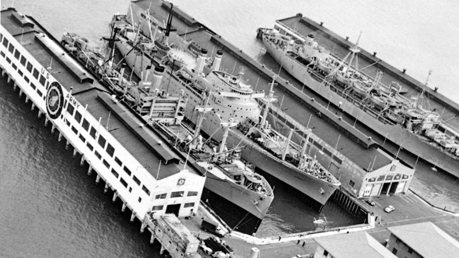 Black and white aerial photo above the port, showing the massive warships that used the port.