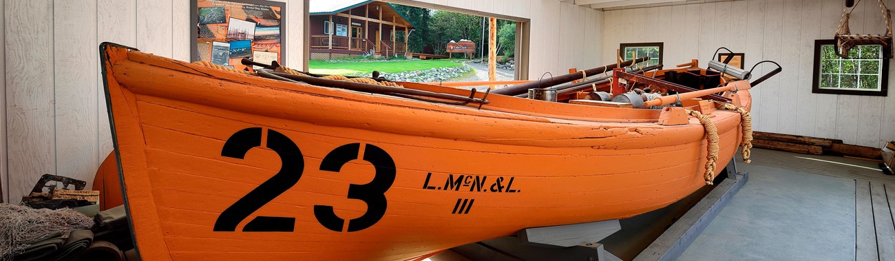 A large wooden boat sits with the number 23 painted on it.