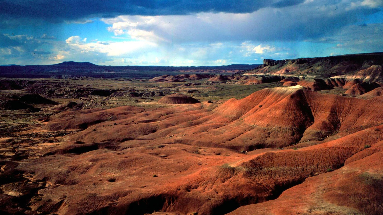 Dark storm clouds above red badlands