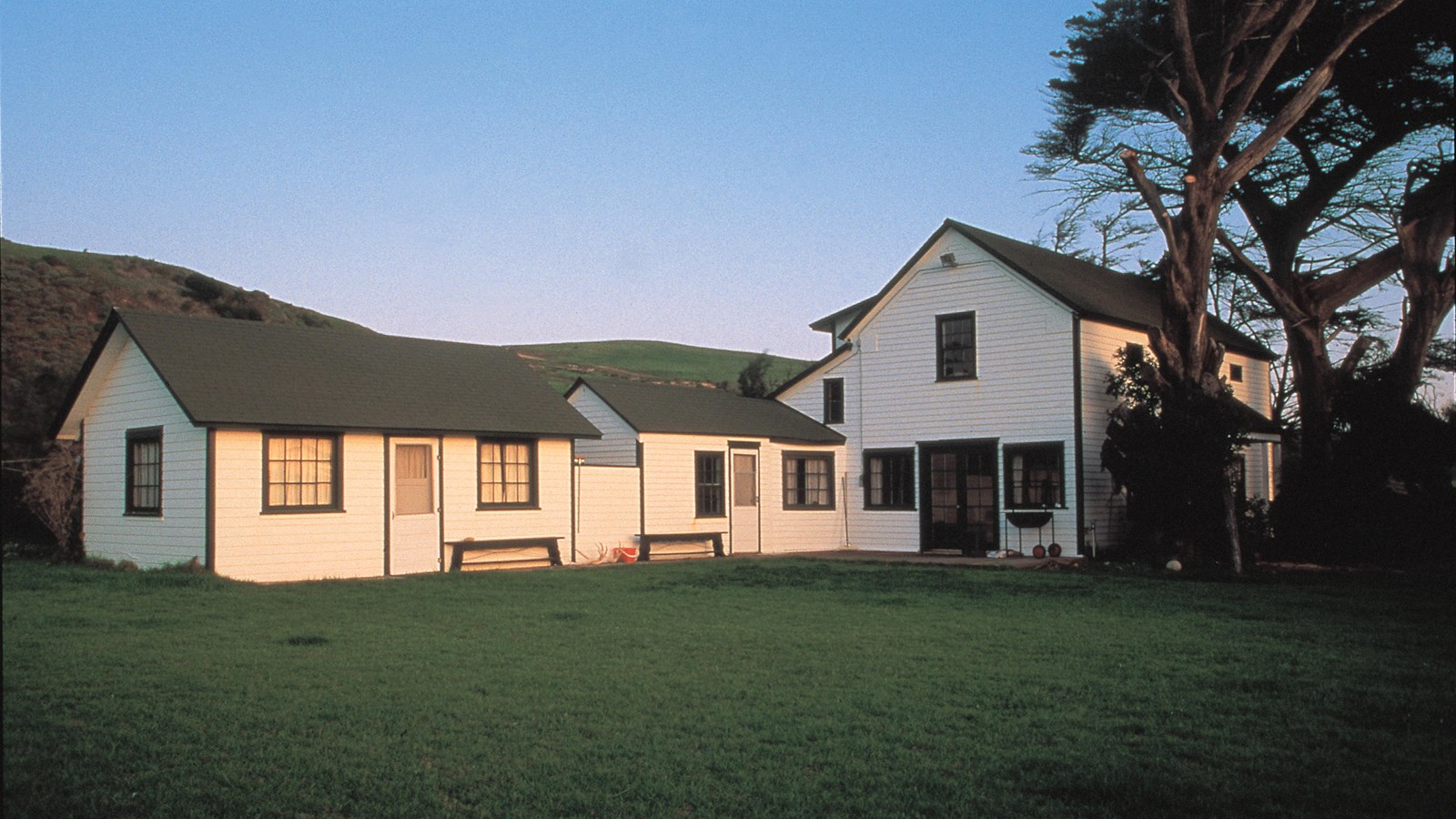 Two story wood ranch house with lawn in front.