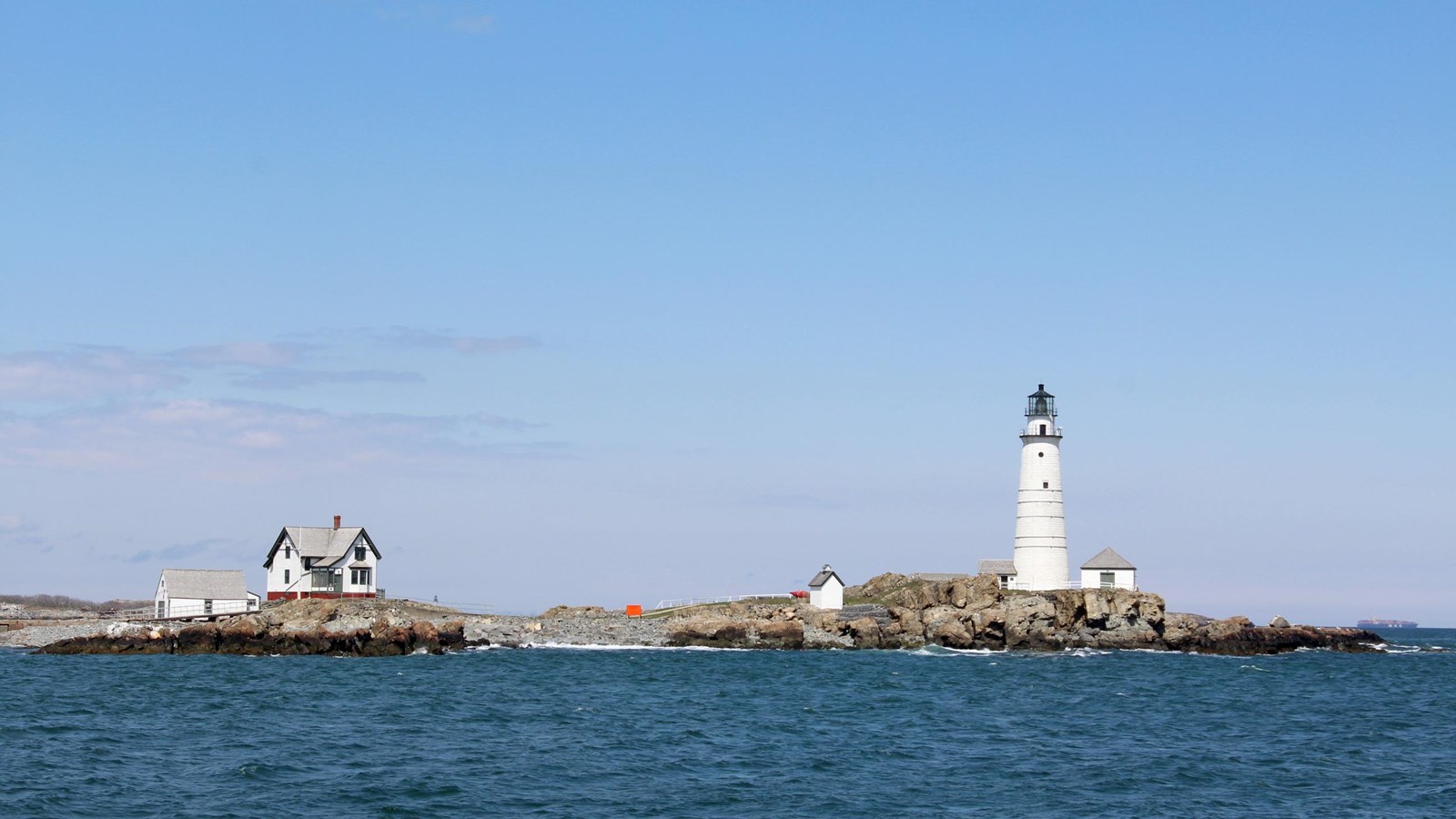 An image of Little Brewster Island from the water, Boston Light, and its outbuildings are visible. 