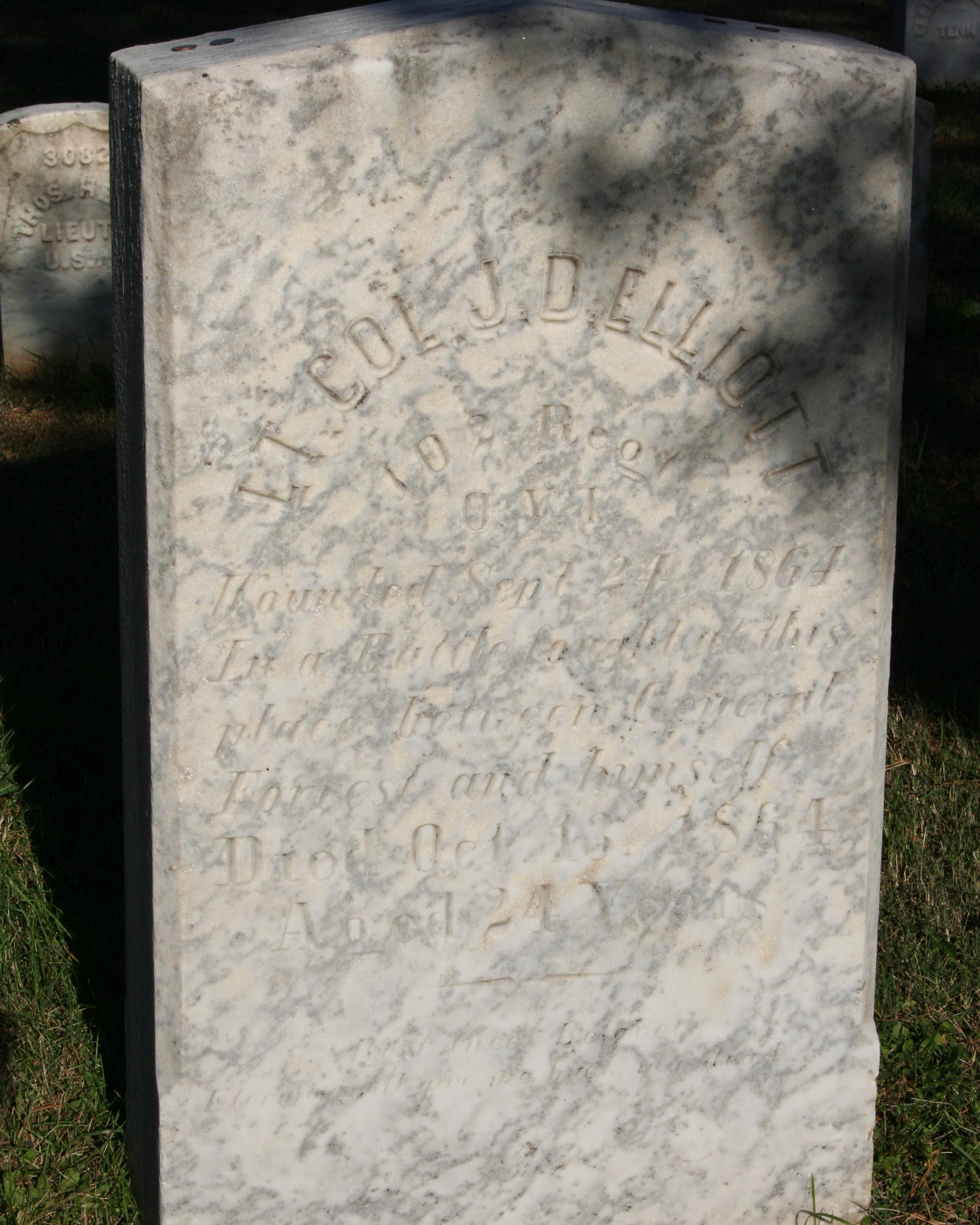 Ornate headstone made out of marble with inscriptions on it. 