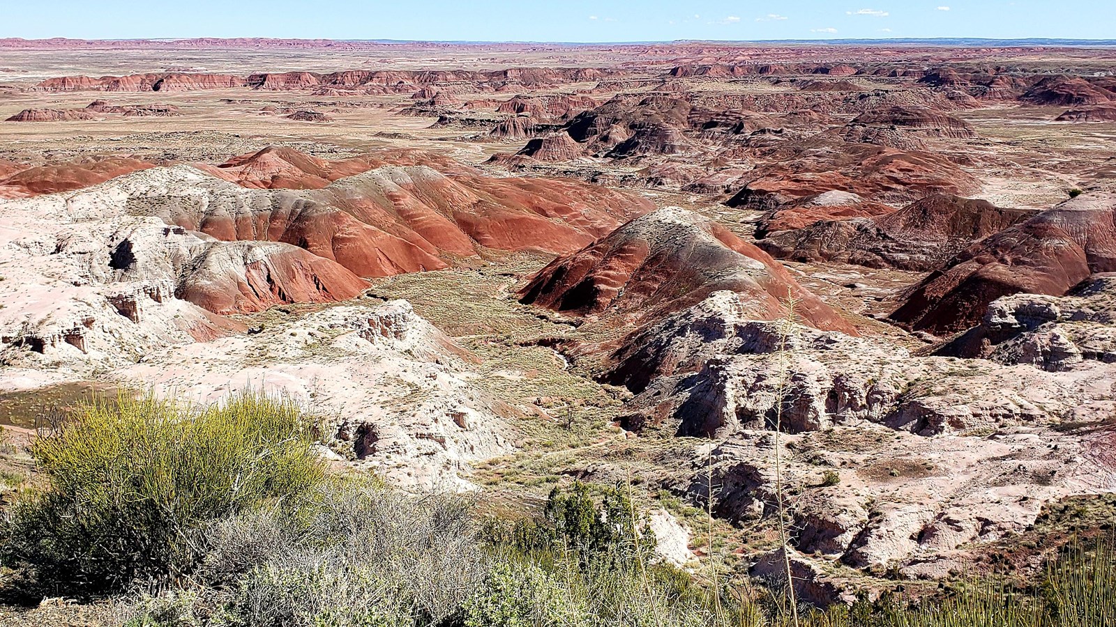 Red and white badlands under a blue sky.