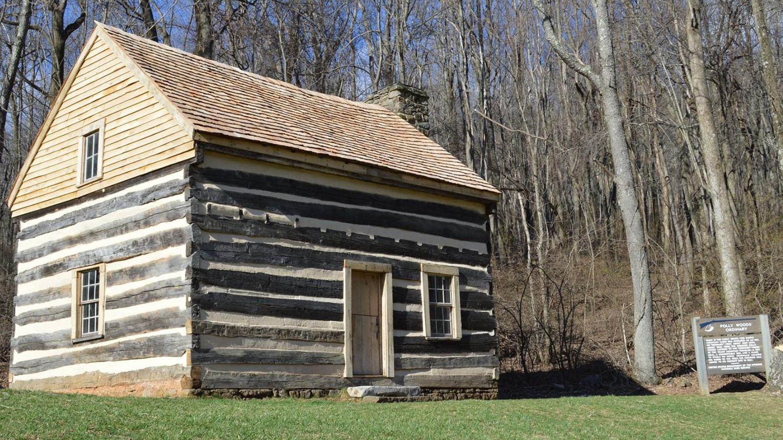 A photo of a restored, simple cabin characteristic of the mid 19th century.