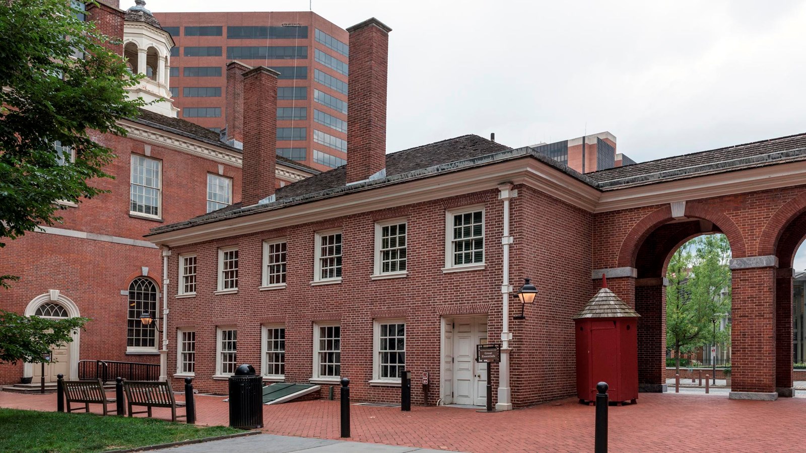The exterior view of a small, two story red brick building