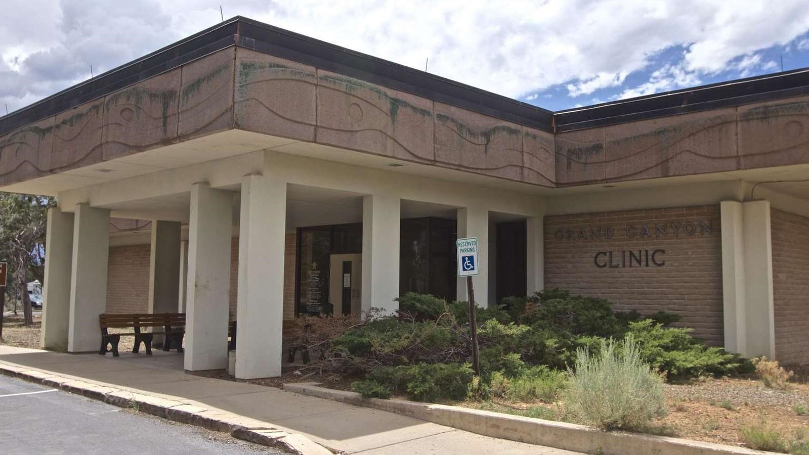 A simple brown and white building next to a paved road.