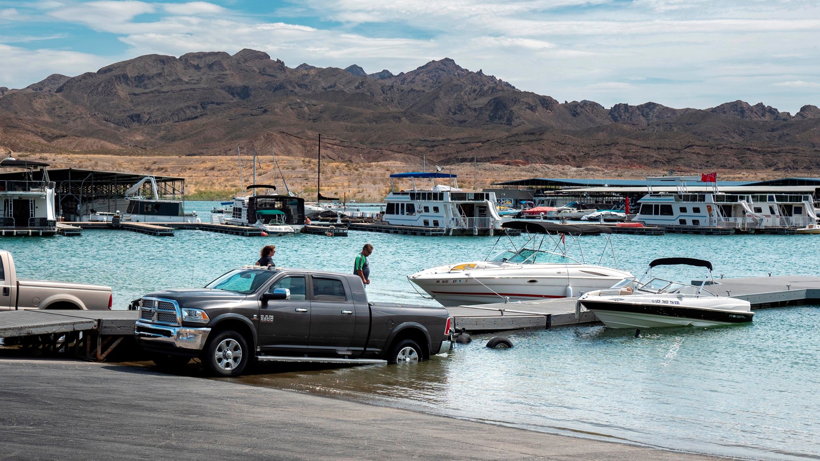 Launch ramp into the lake with several trucks and boats.
