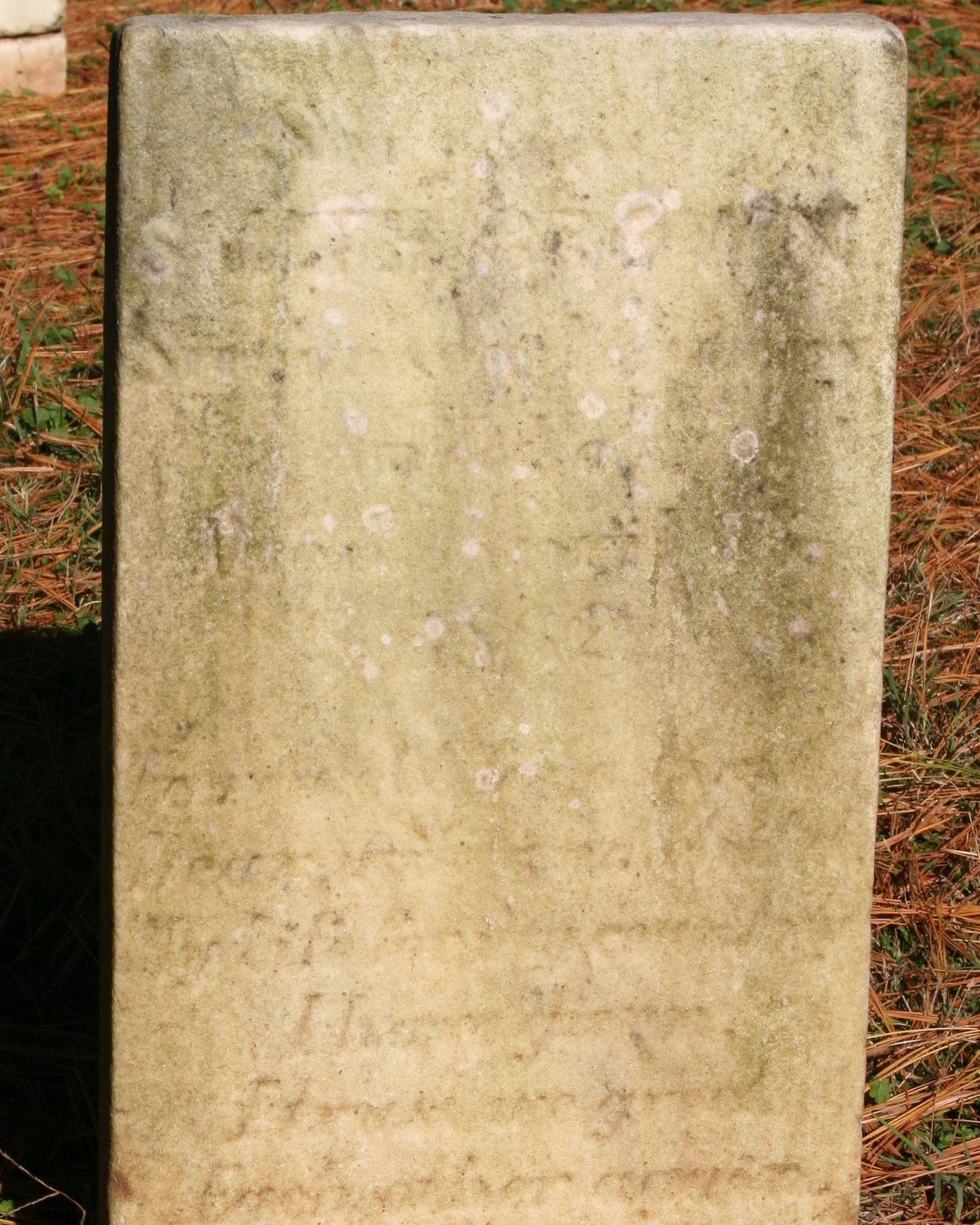 Rectangular marble headstone with inscribed text.