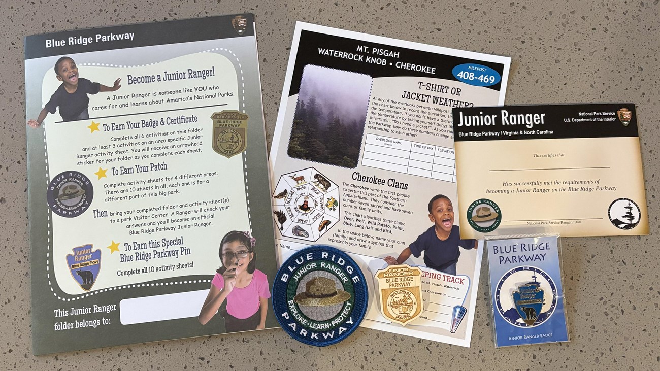 color photograph of the junior ranger activity sheets and wooden badge and fabric patch