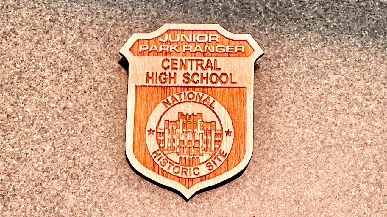 The junior ranger badge features a silhouette of Central High\'s facade and the site name at the top.