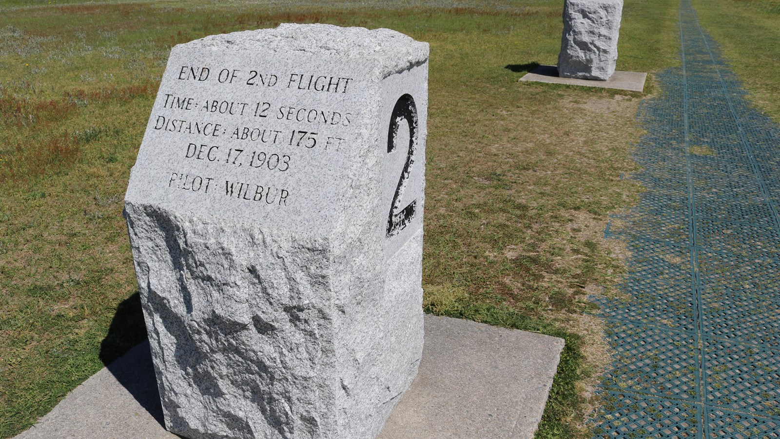 A granite marker listing the pilot, distance and time of the second flight completed by the Wrights.