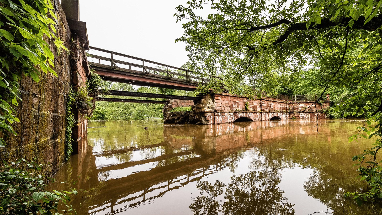 A single arch aqueduct spans a creek.