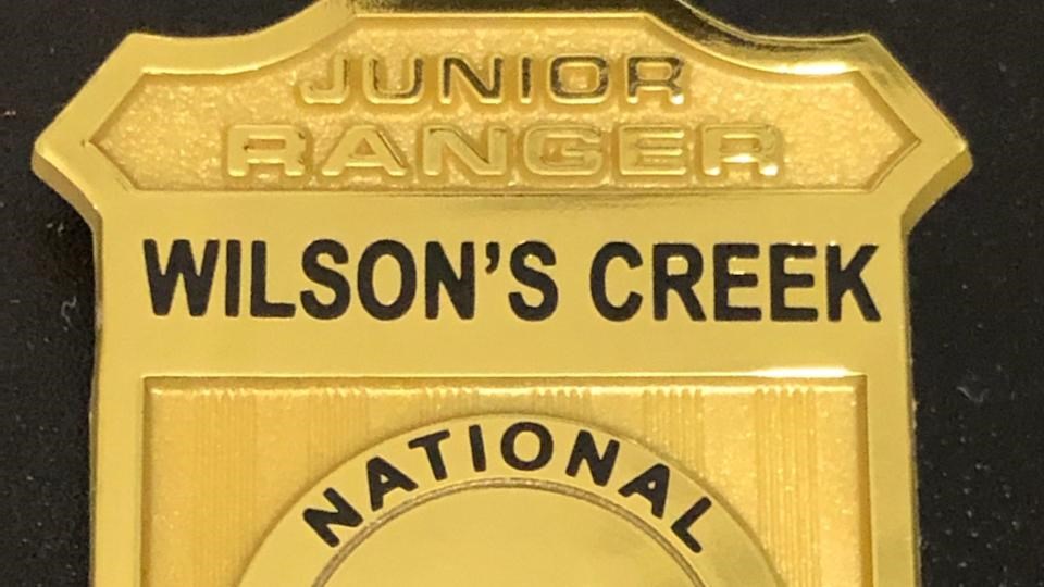 Plastic Junior Ranger badge with Wilson\'s Creek National Battlefield on it and a cannon emblem 