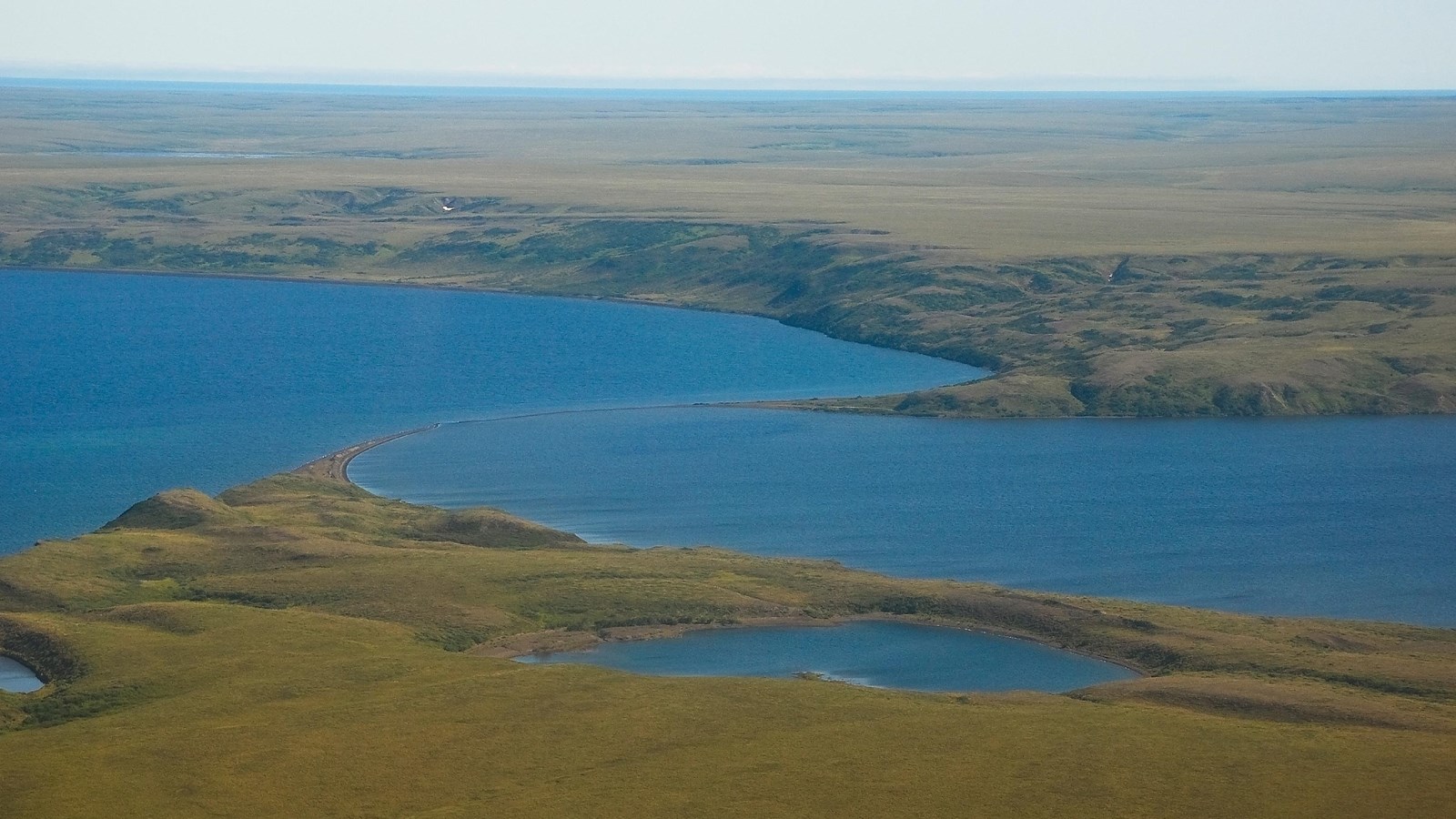 From a bird\'s eye view, are two elliptical lakes connected by a slender sandspit.  