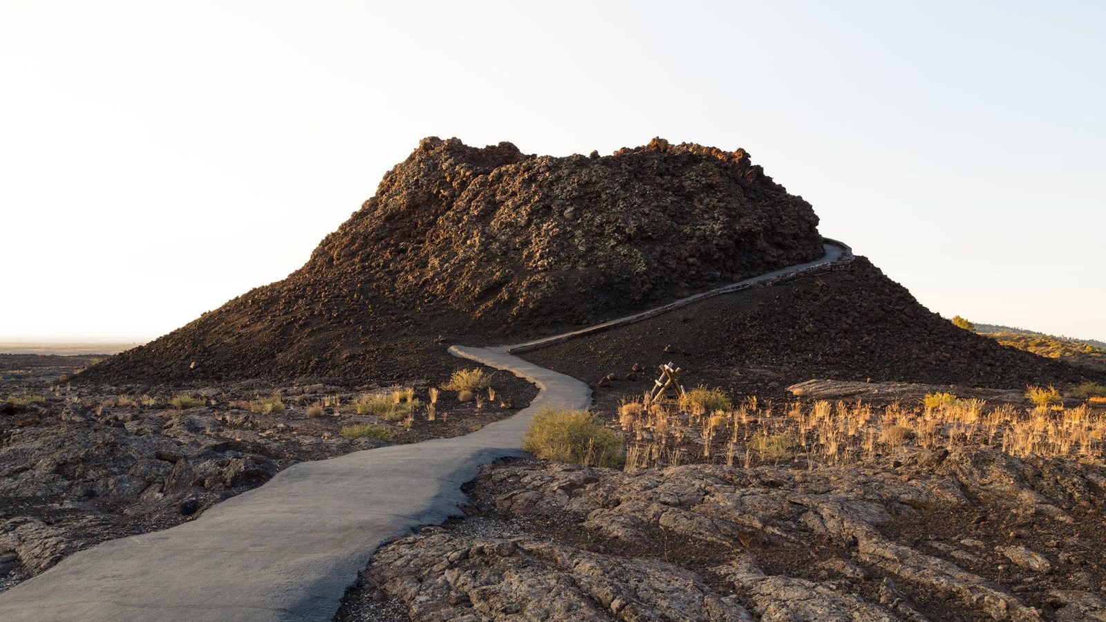 A paved trail winds up the side of a miniature volcano.
