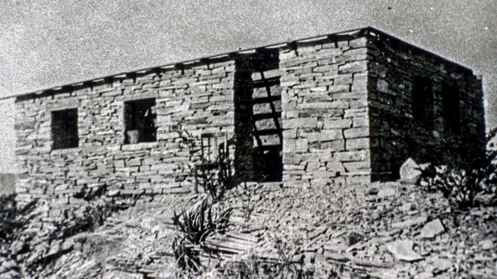 A stone house with two rooms sits on a limestone hill.