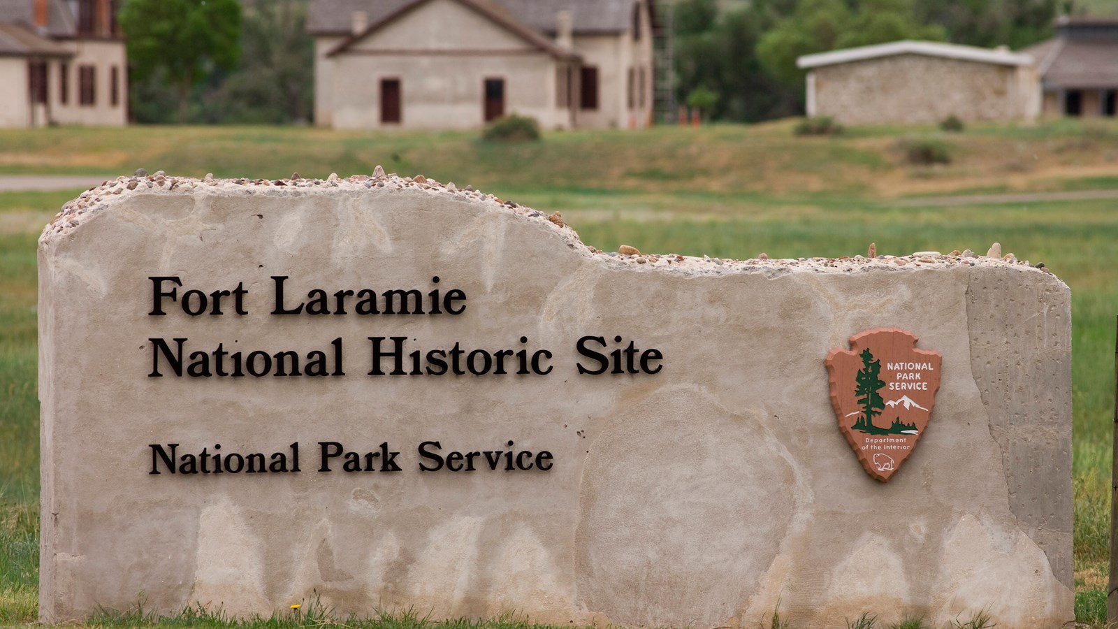 Stone sign at Fort Laramie National Historic Site with NPS emblem