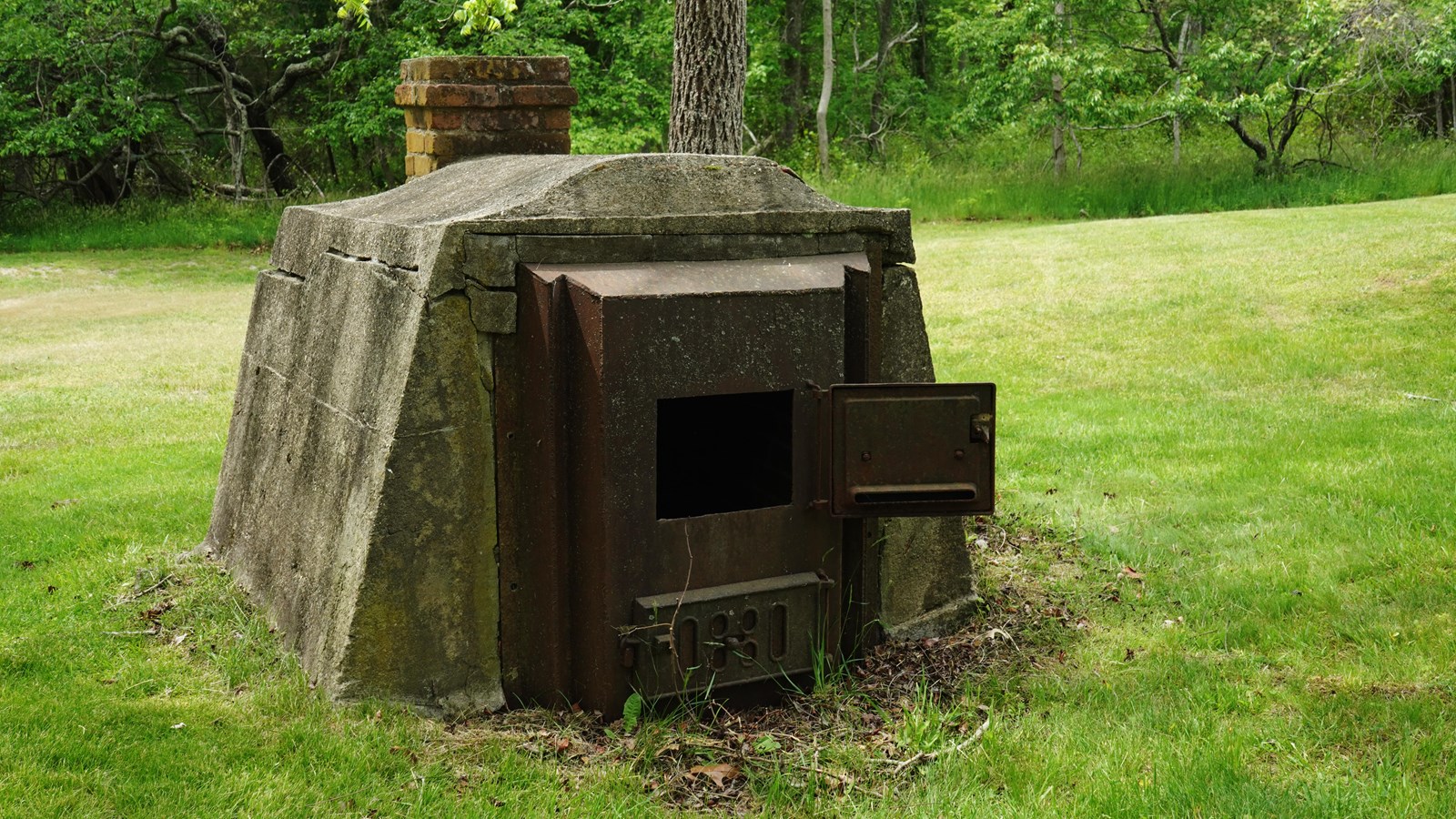 A small box made from metal and concrete with a thick metallic door. 
