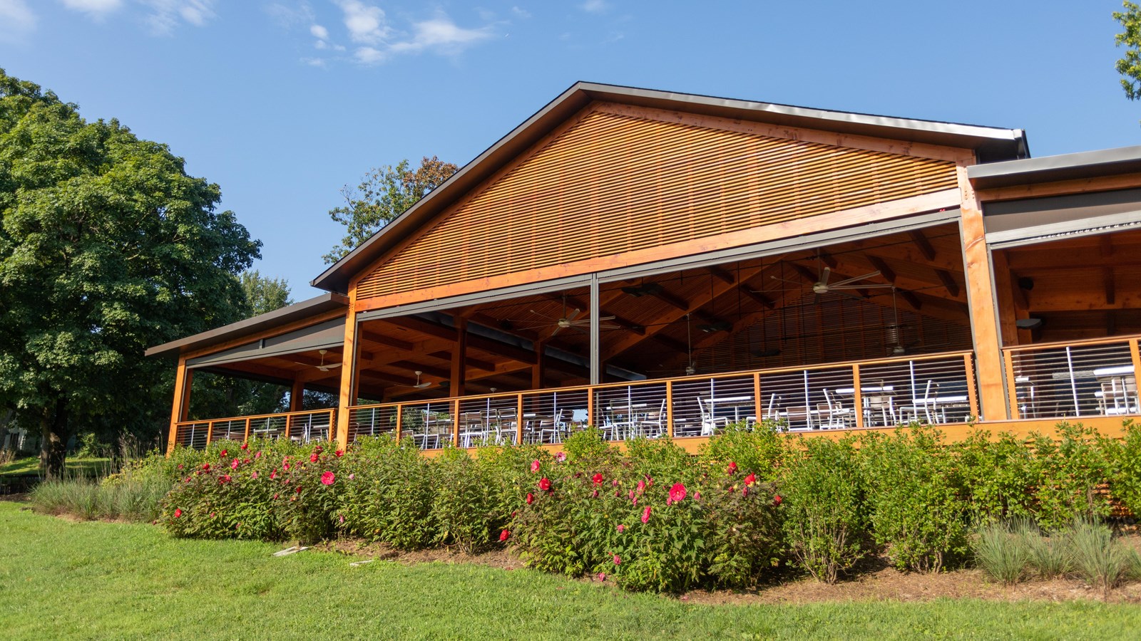 Pavilion with hedges at the base under a blue sky.