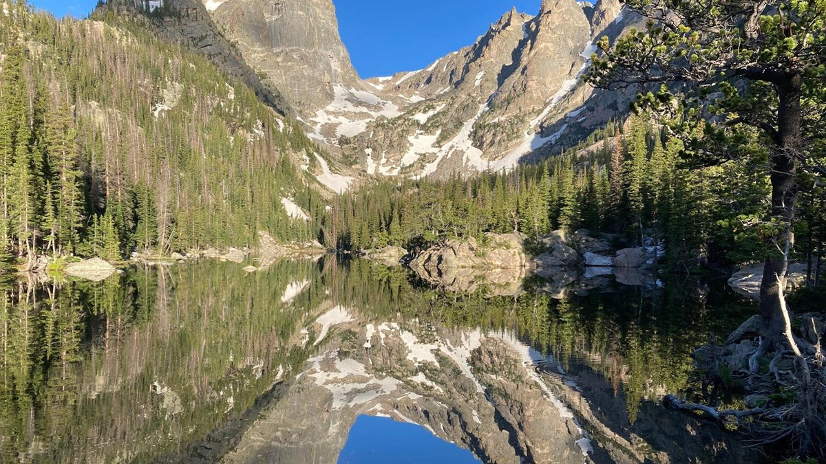 a mountain top is reflected in a lake