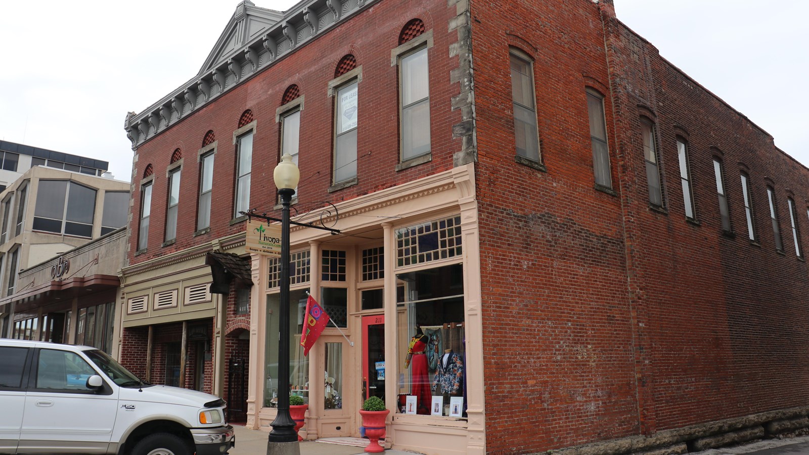A two-story brick building with store front located on the end of a block just off the square.