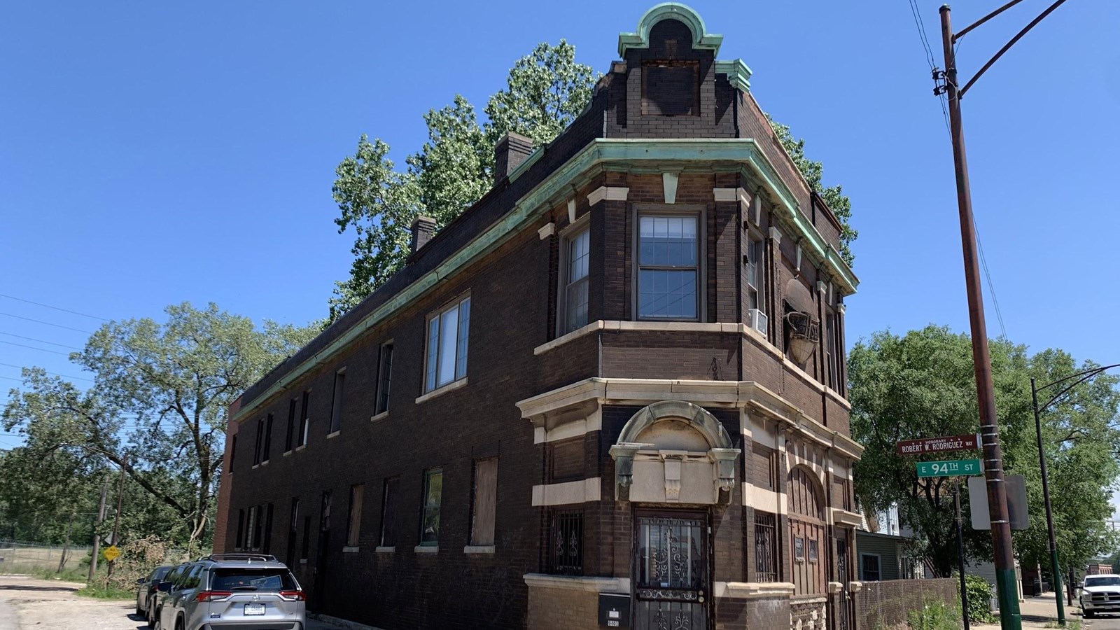 Two story brown brick building on street corner 