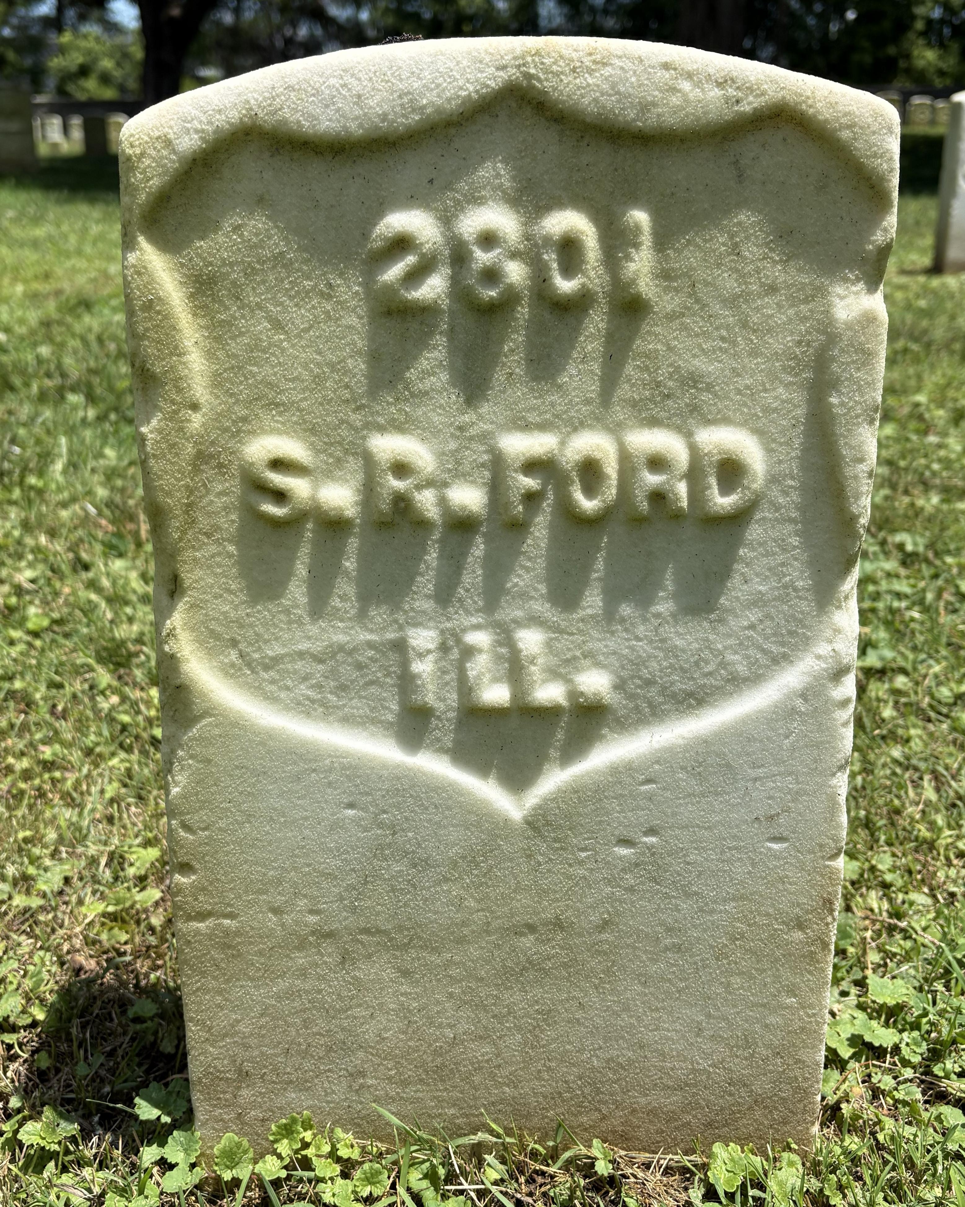 Marble headstone with green tinge. Name on headstone reads "S. R. Ford." 