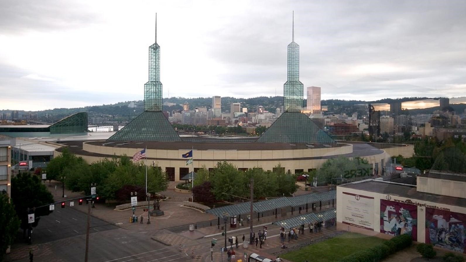 A large circular modern building with two glass spires rising from the roof