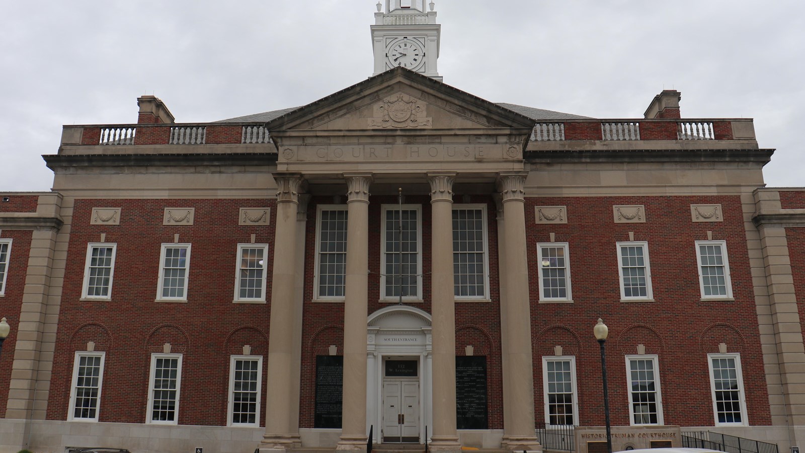 The courthouse is a large two-story brick building that spans the length of the block.