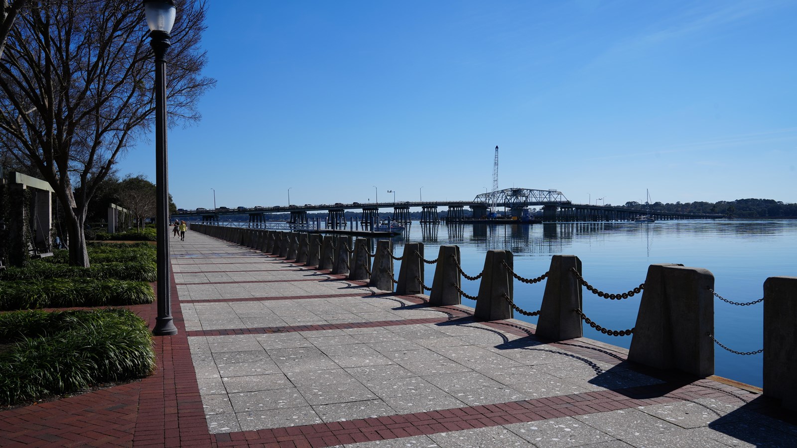 A waterfront park with views of a swing bridge.